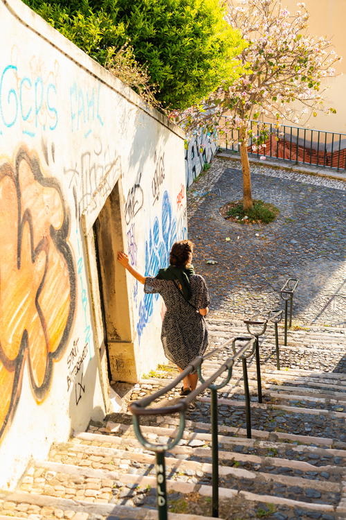 A woman riding a skateboard down a set of stairs.