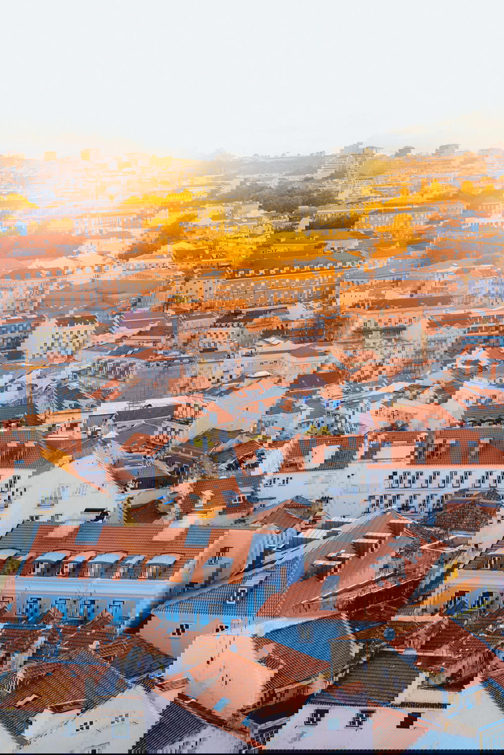 Sun going down against Lisbon tiled rooftop buildings at sunset