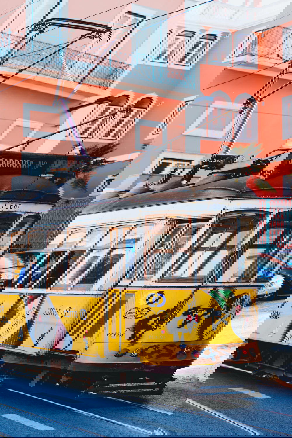 A yellow tram on a street in lisbon, portugal.