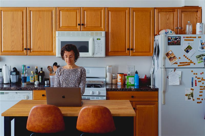 Woman working with a laptop in a kitchen