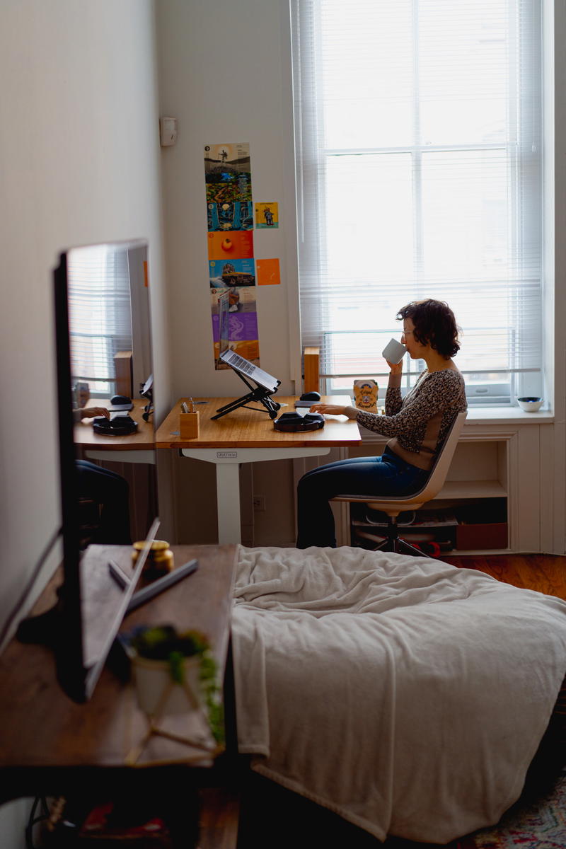 A woman working at a desk in a small room.