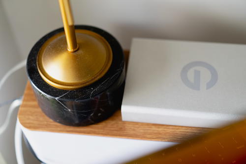 Lamp and hard drive on top of a cable box on top of a desk.