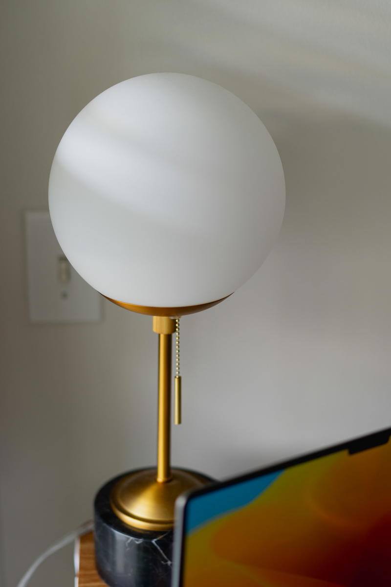 A glass ball-style lamp with black and gold accents.