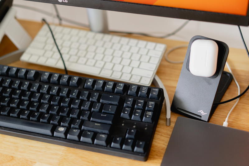 A black mechanical keyboard with an Apple Magic Keyboard in the background.