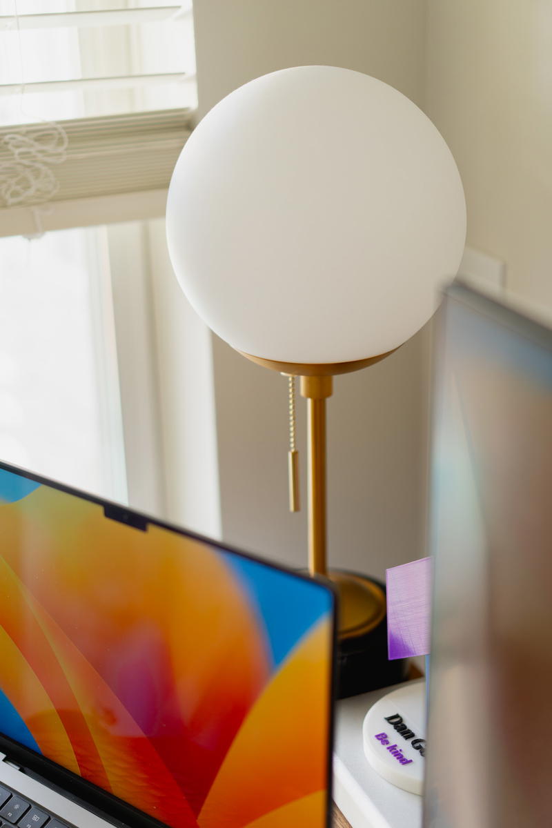 A circular-style desk lamp with gold accents.