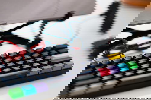External mechanical keyboard with rainbow multicolor keys on a home office desk