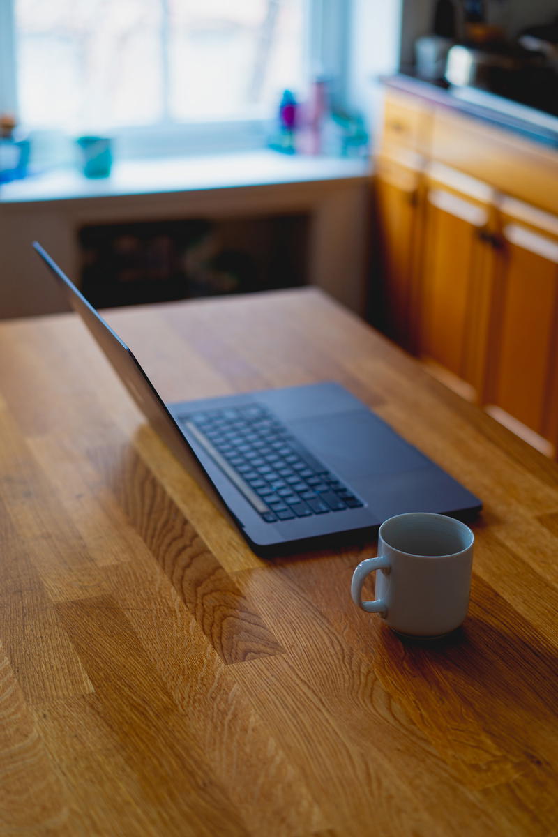 Apple MacBook Pro 16" on a wooden table with a cup of coffee