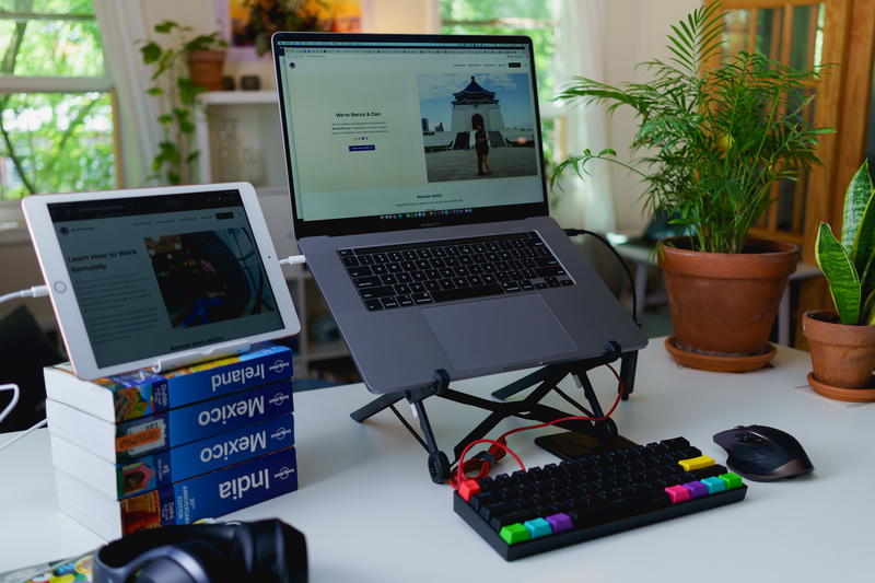 Laptop stand on a standing desk with external keyboard in a home office in an apartment