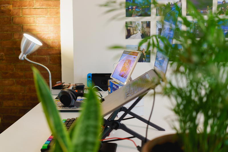 Home office setup on a standing desk with external keyboard, laptop on a laptop stand and ipad as an external monitor