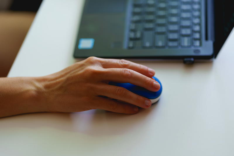 Using a wireless mini mouse with a laptop on a small desk in a home office