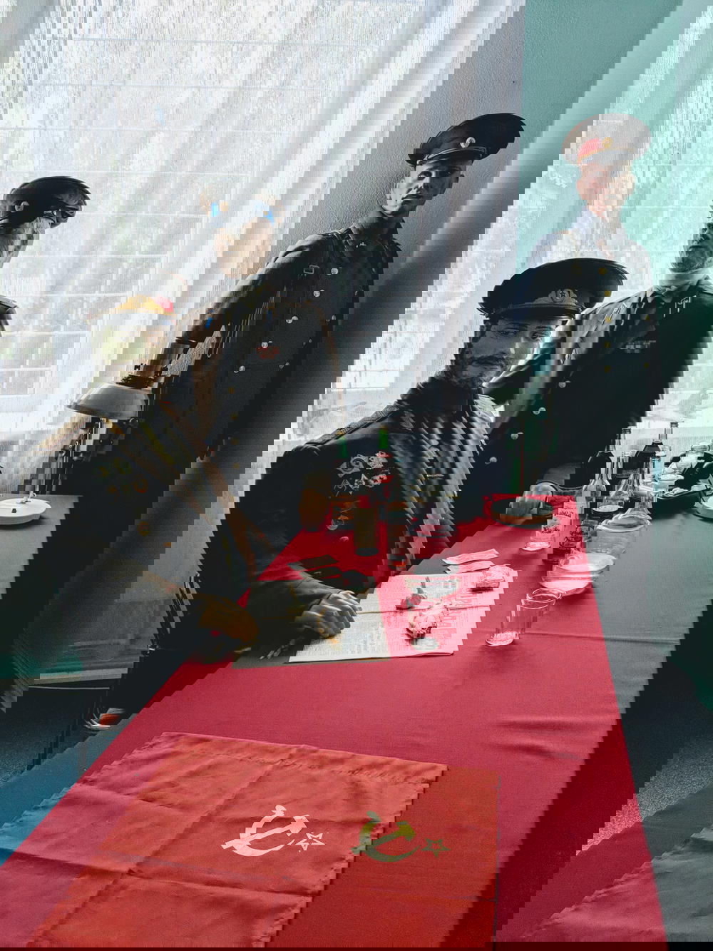 Three mannequins sitting at a table.