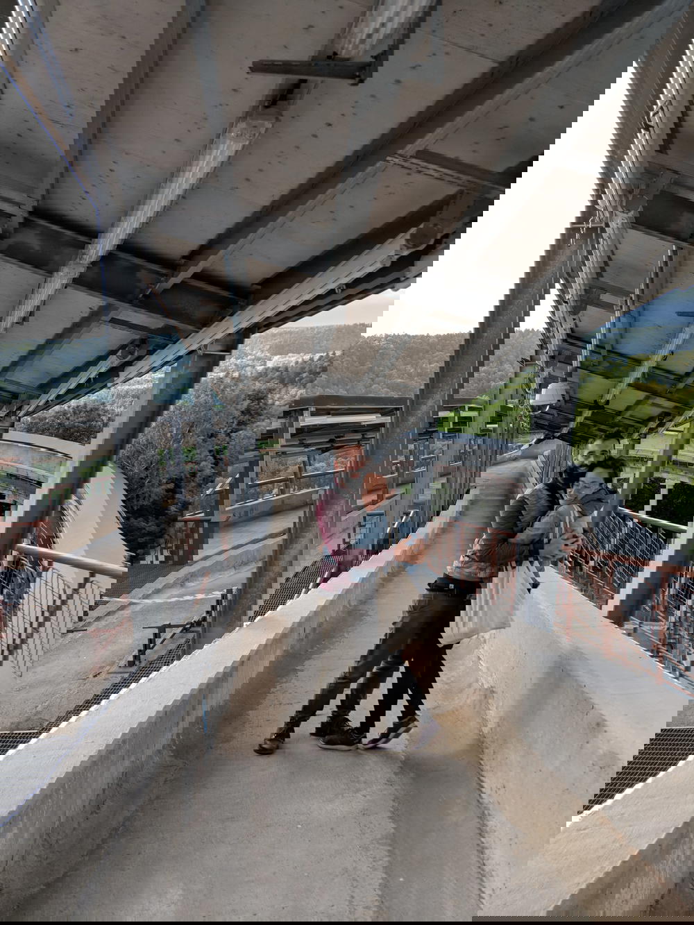 A man and woman hugging on a bridge.