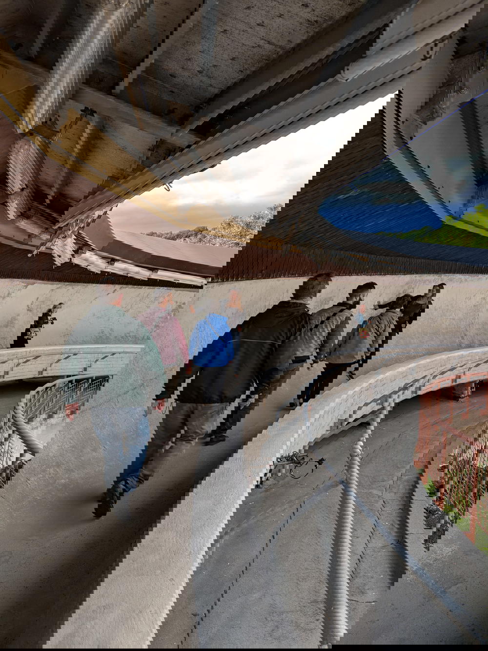 A group of people walking down a curved walkway.