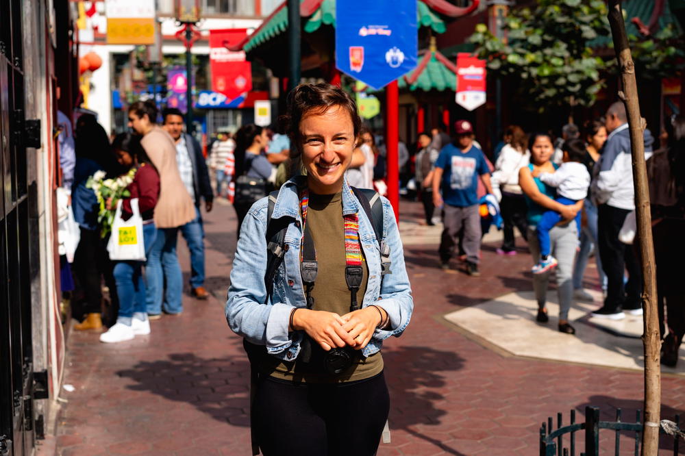 A woman standing on a street in a city.