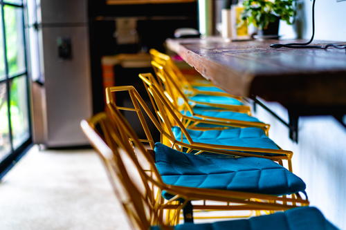 Yellow chairs with blue cushions under a wooden countertop