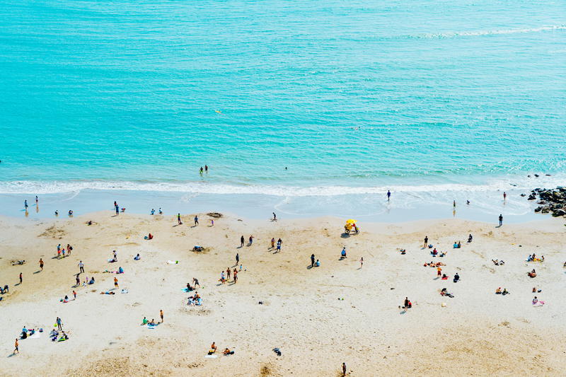White sand beach in Lima Peru with beachgoers heading into the ocean