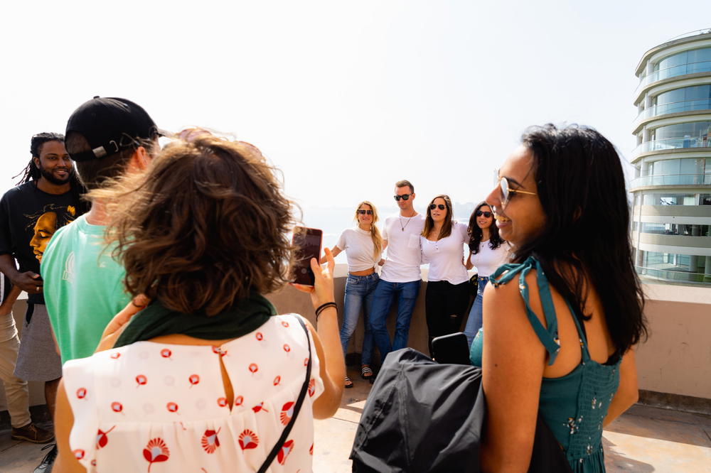 A group of people taking pictures on a rooftop.