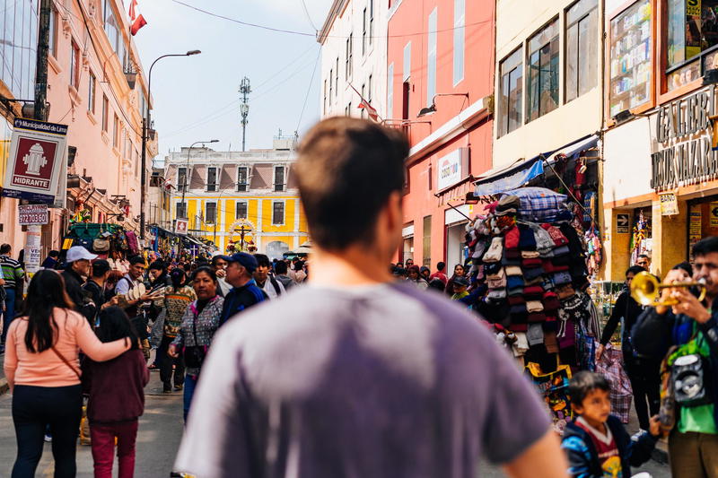A man walking down a crowded street in a city.