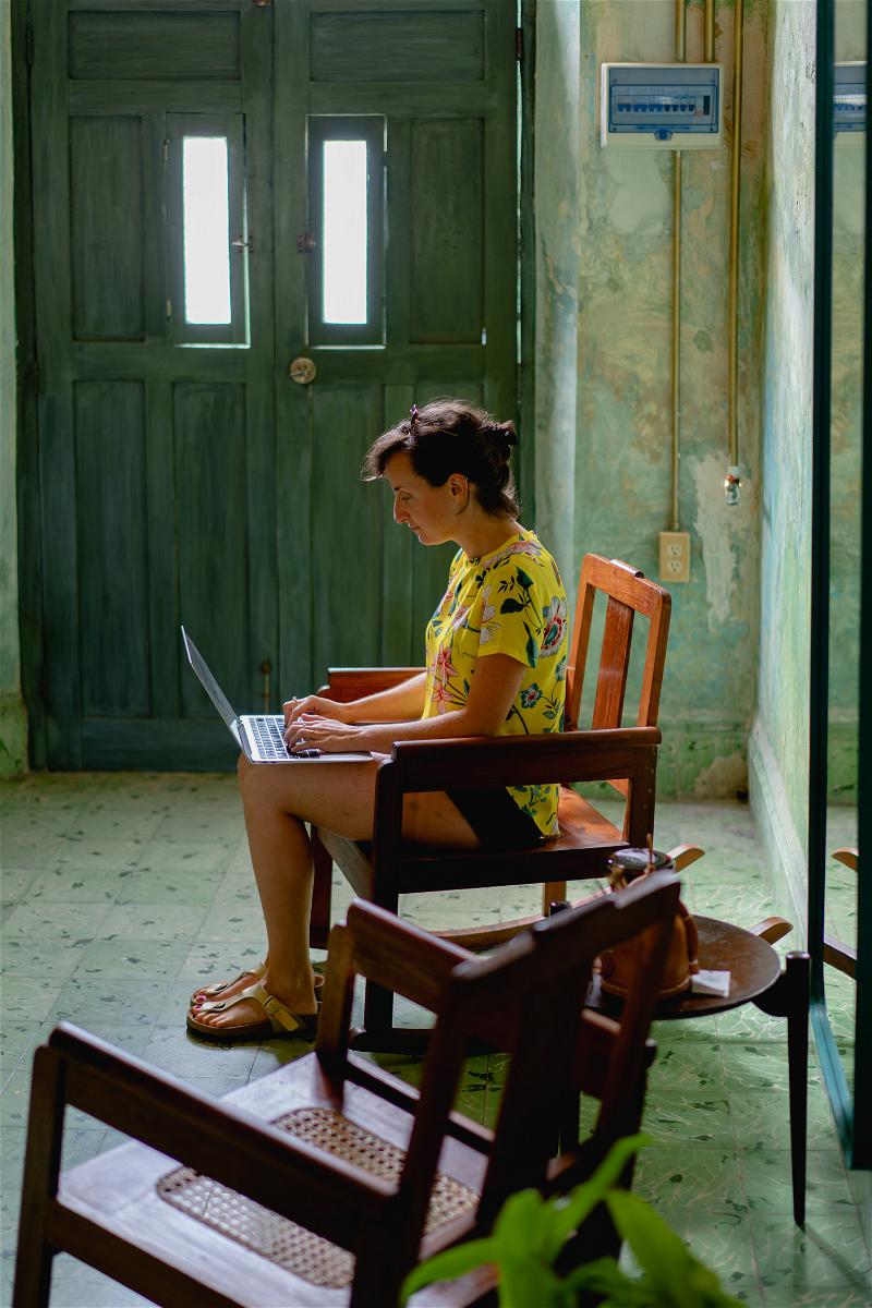 A woman sitting in a chair using a laptop.