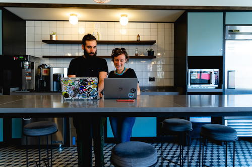 Two people working at a table in a kitchen.