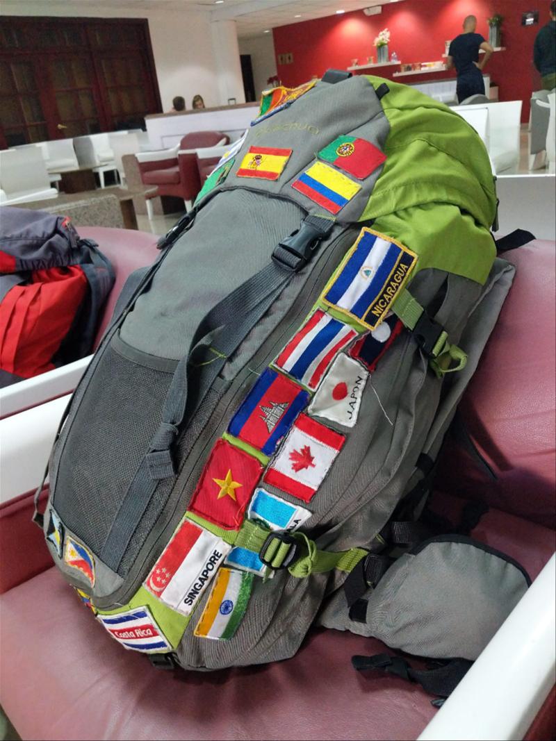 A backpack with a lot of different flags on it.