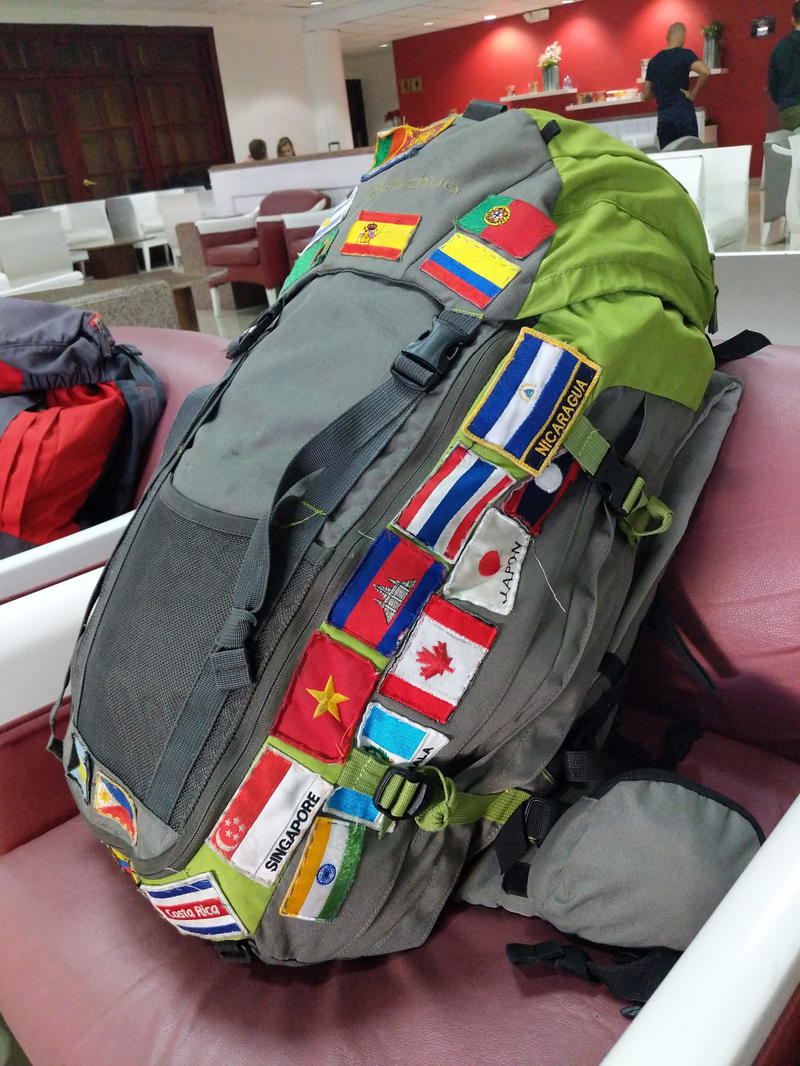 A backpack with a lot of different flags on it.