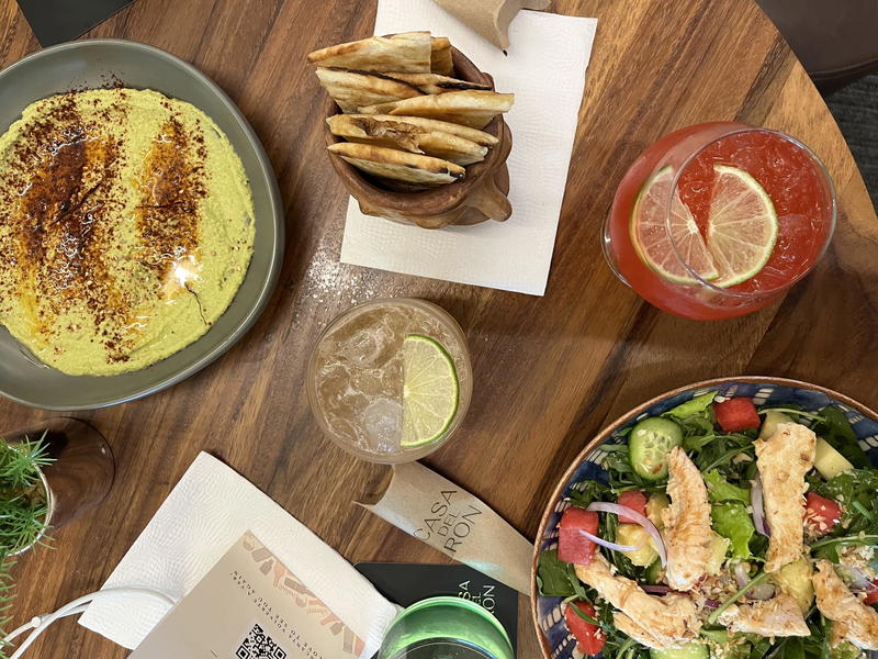 A table full of food and drinks on a wooden table.