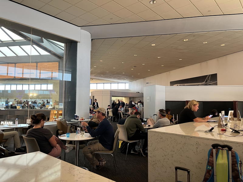 A group of people sitting at a table in an airport.