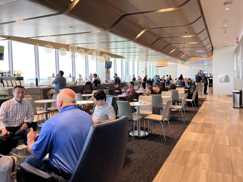 A group of people sitting at tables in an airport.