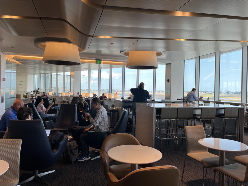 A group of people sitting at tables in an airport.