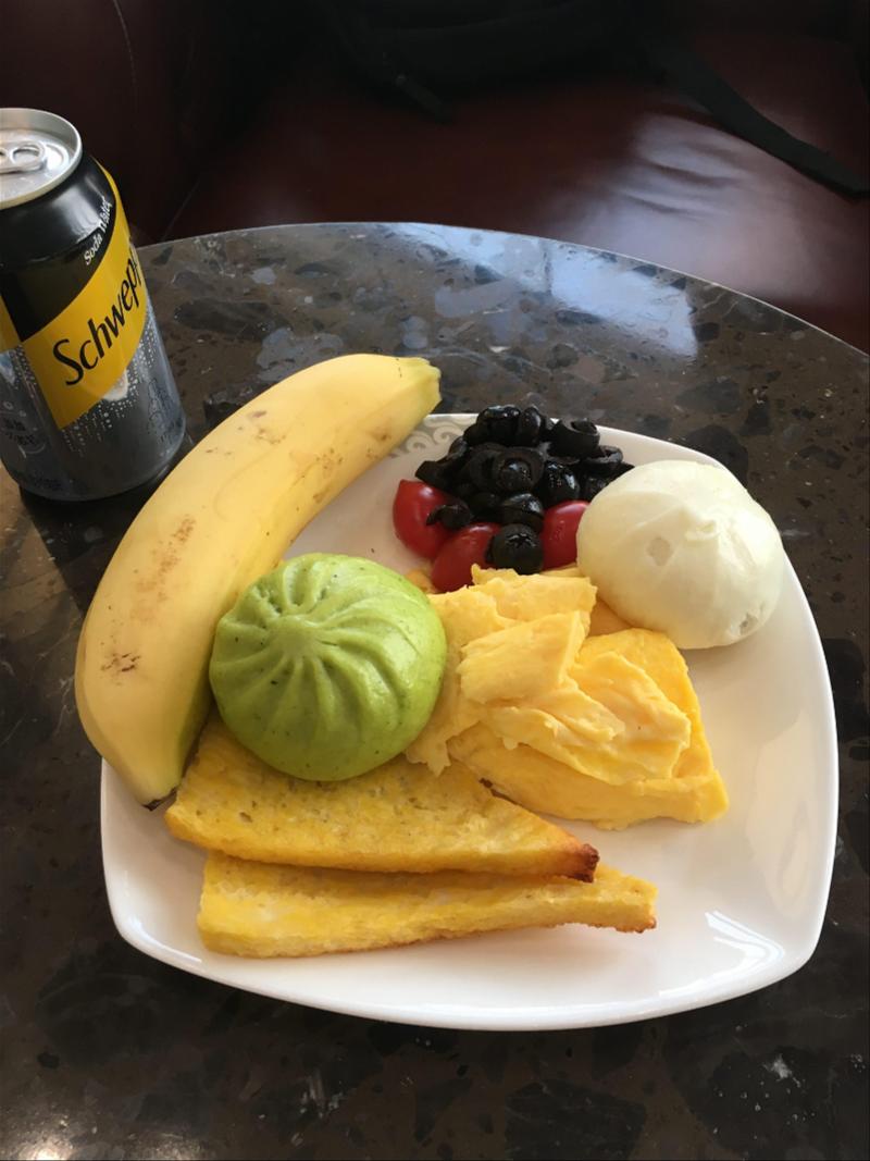 A plate of fruit and a beer on a table.