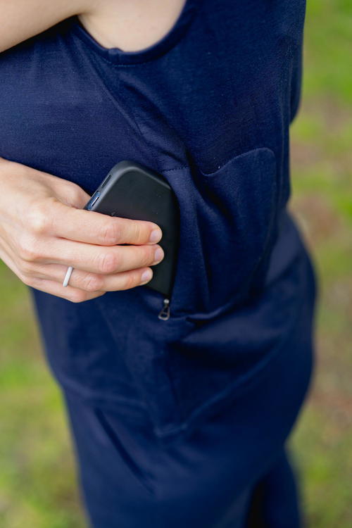 A woman holding a Bluffworks Cowl neck top in her pocket.