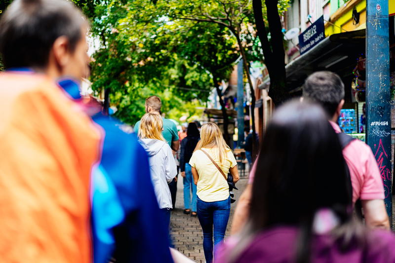 A group of people walking down a sidewalk.