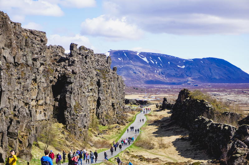 A group of people walking along a rocky path in iceland.
