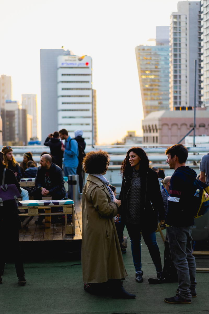 A group of people standing on a sidewalk.