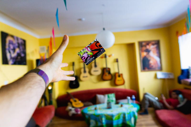 A person is holding up a card in a living room.
