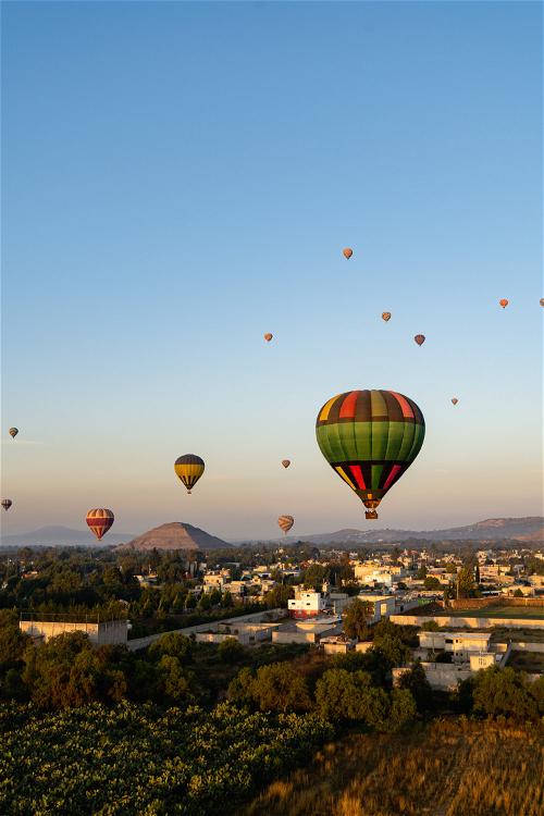 Hot air balloons flying at sunrise over Teotihuacan Mexico