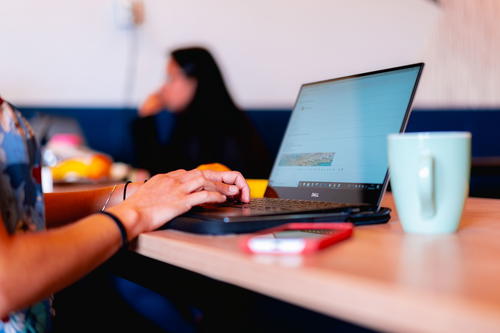 Close up of digital nomad remote working on a laptop at a coworking space