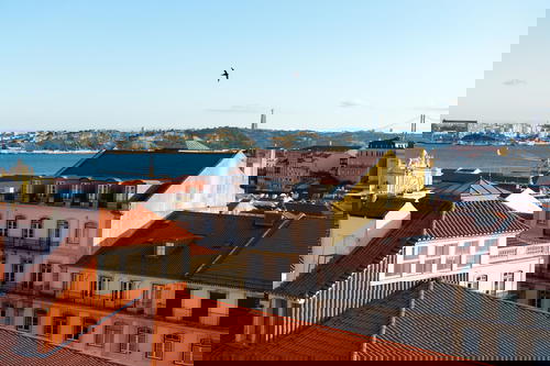 Blue sky, river and red rooftops of historic buildings and architecture in Lisbon