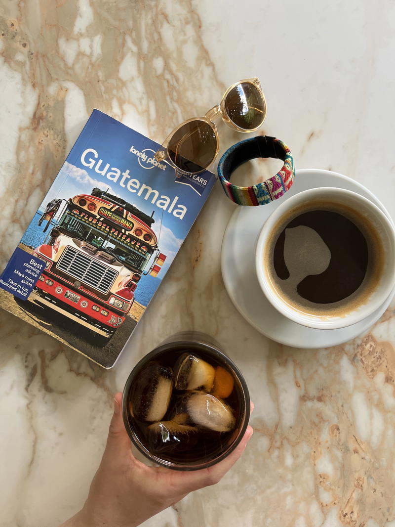 A person holding a book and a cup of coffee.