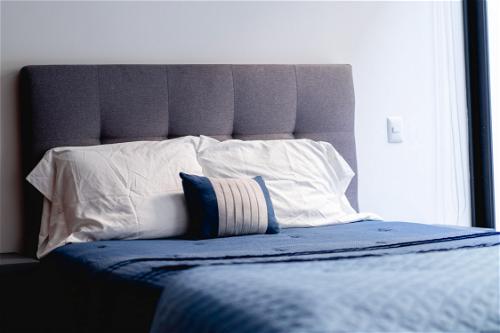 A bed with a blue comforter.