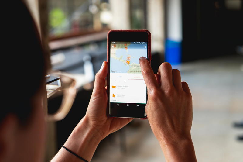 A woman is holding up a smartphone with a map on it.