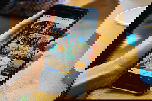 A person holding a smartphone with pictures on it.