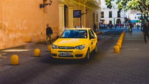 A yellow taxi parked on a street.