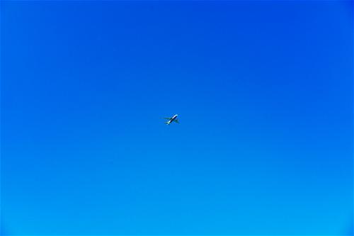 A plane flying in a clear blue sky.