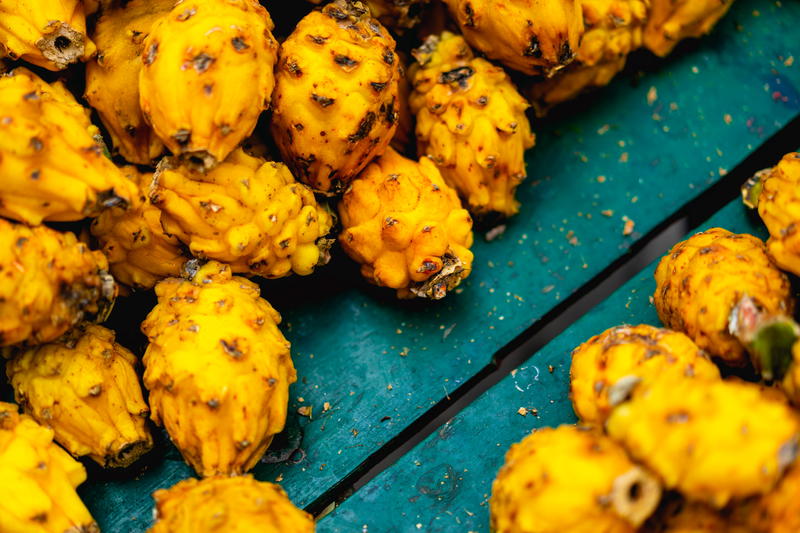 Pitahaya fruits on blue wooden boards in a vendor cart in Medellin, Colombia.