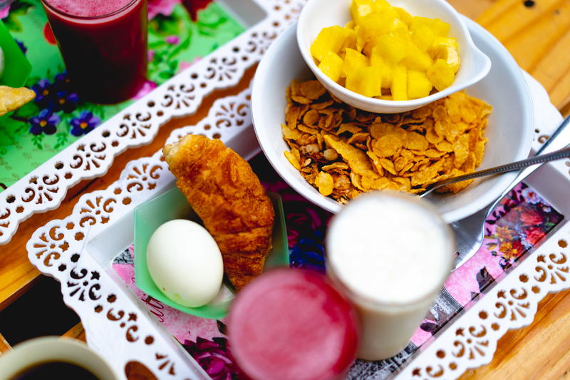 Colombian breakfast of pineapple, cereal, milk, a hard boiled egg, one croissant a fresh juice in Santa Fe de Antioquia.