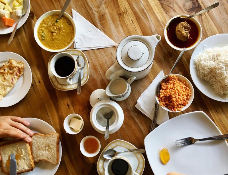 Breakfast spread at a restaurant in Ella, Sri Lanka, with typical Sri Lankan breakfast foods and coffee and toast.