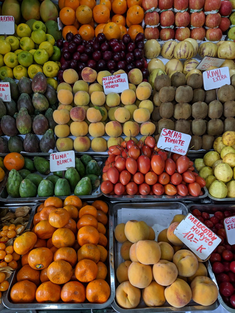 Fresh fruits of tuna, peaches, tomate de arbol and kiwis stacked and for sale at a market in Lima, Peru.