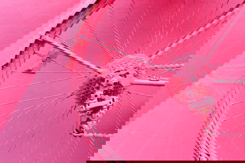 Bicycle wheel painted pink against a pink wall on Calle Rosada in Puerto Plata Dominican Republic